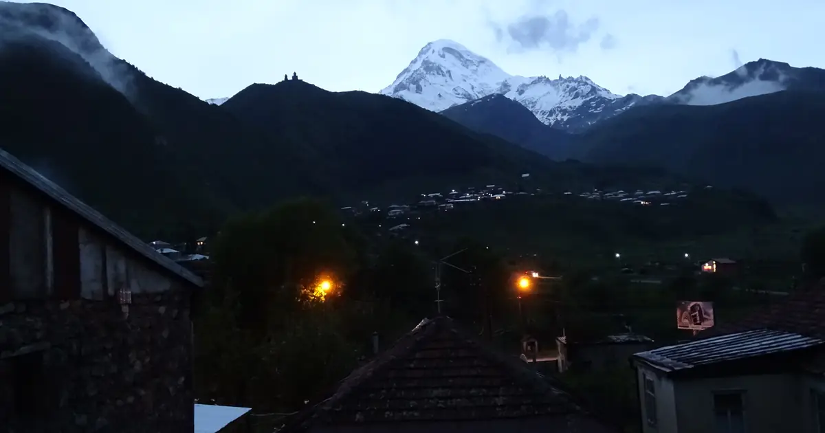 Snowy Kazbek above Stepantsminda at dusk