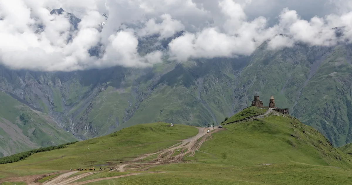 Gergeti Church on the hill under clouds in Kazbegi